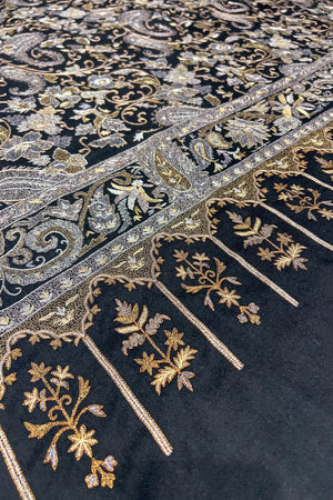 Detail of tilla jaal border and field meeting point on black pashmina shawl, gold and silver tilla visible