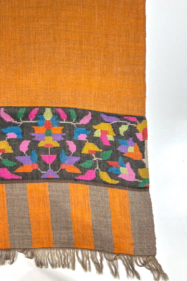 Textile with colorful bird pattern on a black background and orange stripes.