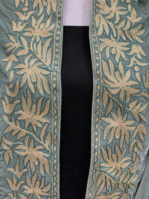 #MintGreen Close-up of a green fabric with gold floral embroidery on a black background