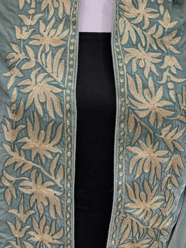 #MintGreen Close-up of a green fabric with gold floral embroidery on a black background