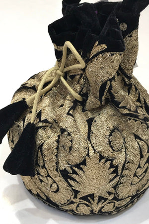 #black Decorative bag with intricate gold patterns and black accents on a white background