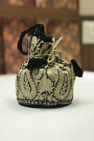#black Decorative drawstring bag with intricate patterns on a white surface.
