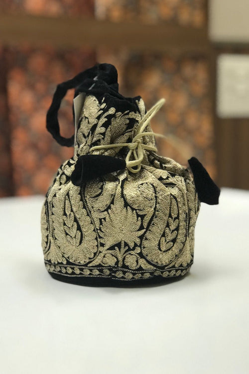 #black Decorative drawstring bag with intricate patterns on a white surface.