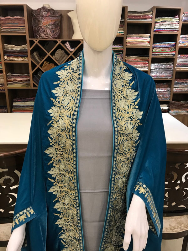 #Turquoise Mannequin wearing a blue embroidered garment in a fabric store setting