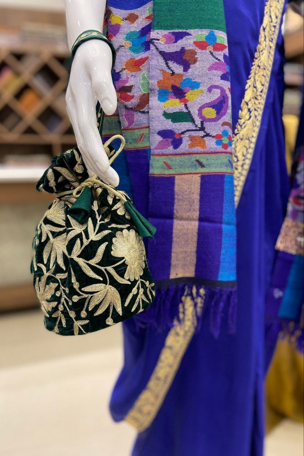 #BottleGreen Mannequin hand holding a black floral bag with a colorful background