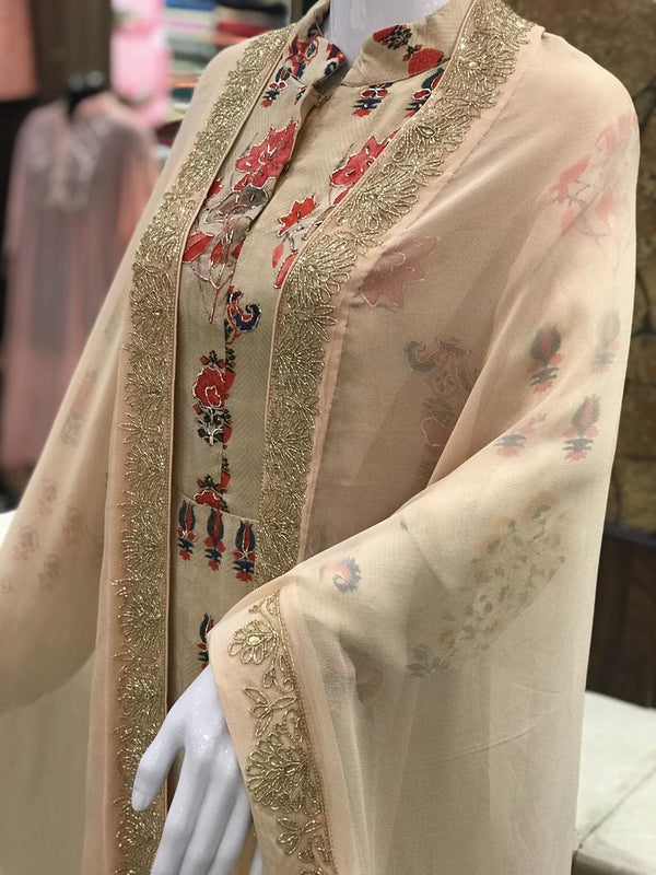 Beige embroidered traditional outfit on a mannequin with a blurred background