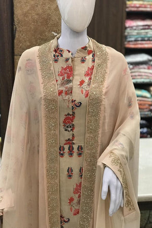 Mannequin wearing a beige embroidered garment with floral patterns in a store setting.