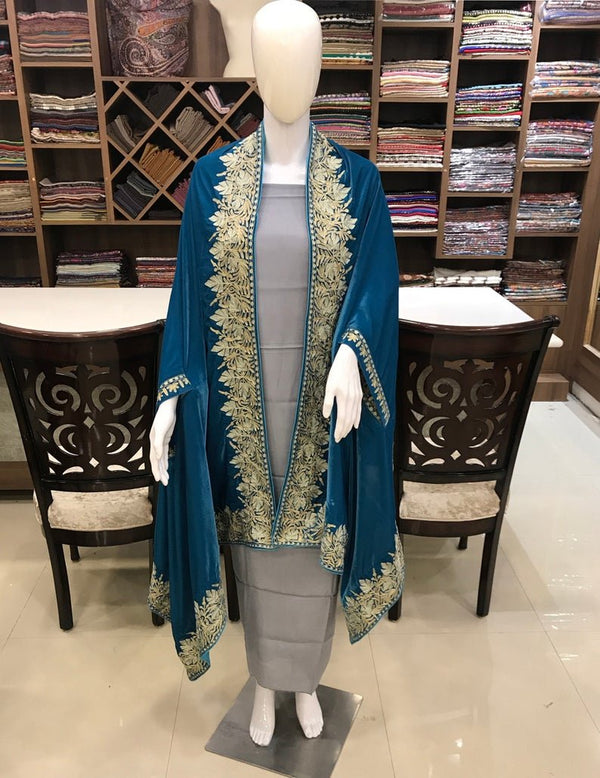 #Turquoise Mannequin wearing a blue and gold embroidered outfit in a fabric store.