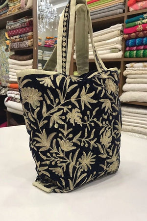 Floral patterned tote bag on a table with fabric rolls in the background