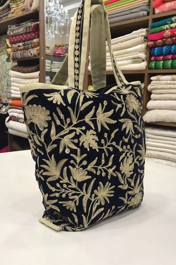 Floral patterned tote bag on a table with fabric rolls in the background
