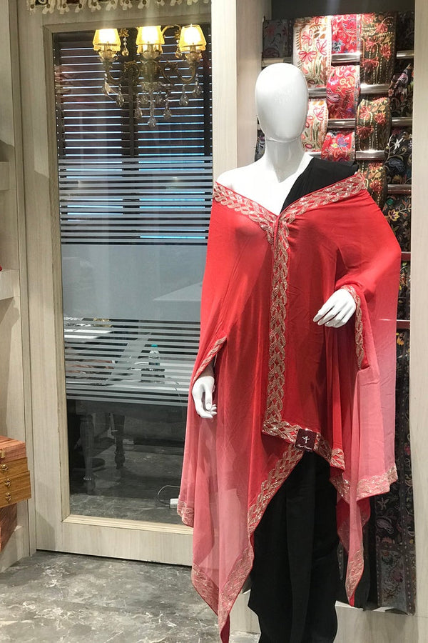 Mannequin wearing a red and black outfit with intricate patterns in a store setting.