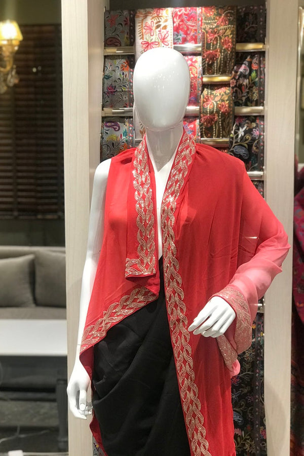 Mannequin wearing a red outfit with gold embroidery in a store setting