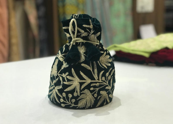 #bottlegreen fabric bag with gold floral patterns on a white surface