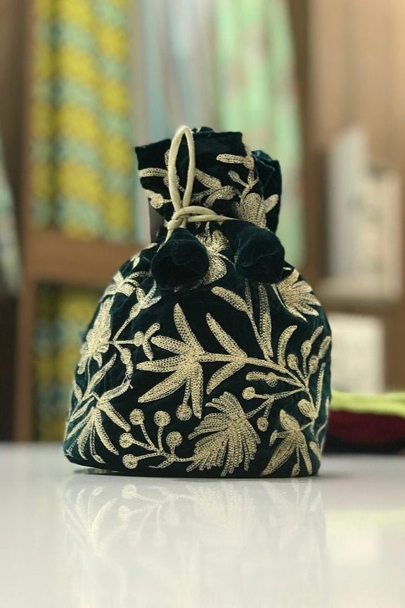 #bottlegreen fabric bag with gold floral patterns on a white surface