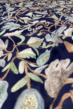 Close-up of embroidered fabric with floral patterns on a dark background