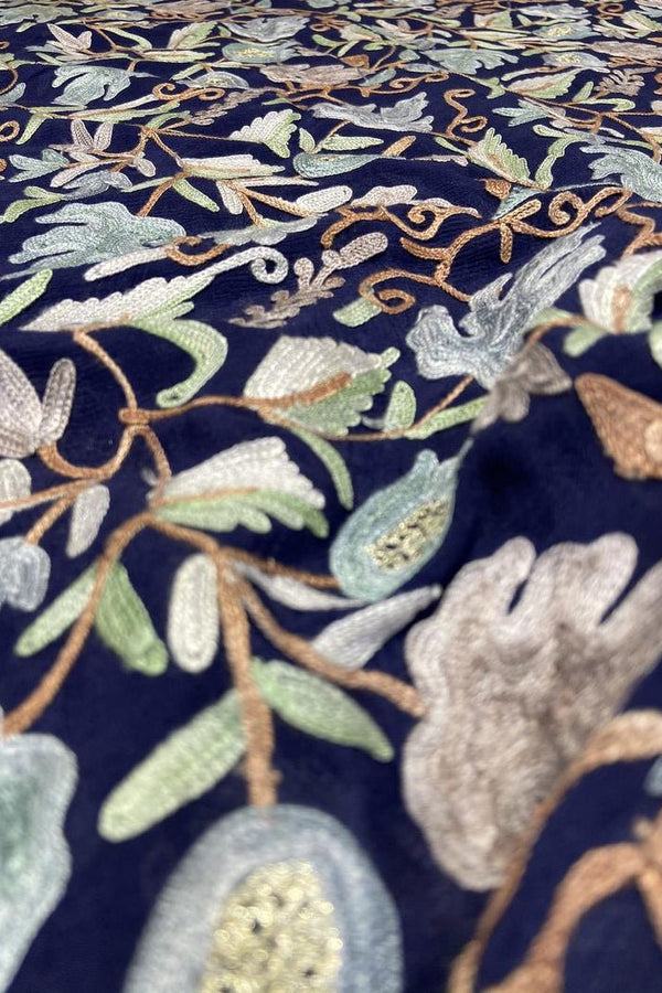 Close-up of embroidered fabric with floral patterns on a dark background