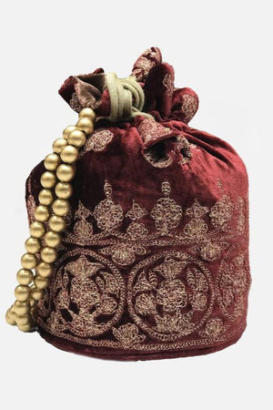 Decorative red potli bag with gold embroidery and a string of pearls on a white background