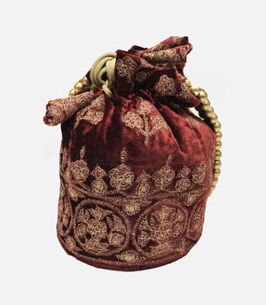 Decorative red velvet bag with gold embroidery on a white background