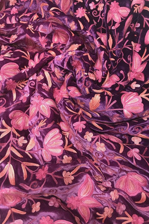 Close-up of floral fabric with pink and purple flowers on a dark background