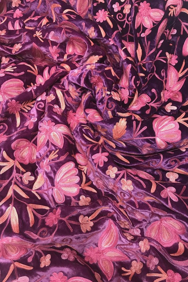 Close-up of floral fabric with pink and purple flowers on a dark background