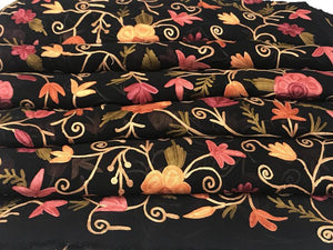 Floral patterned fabric with pink, orange, and yellow flowers on a black background