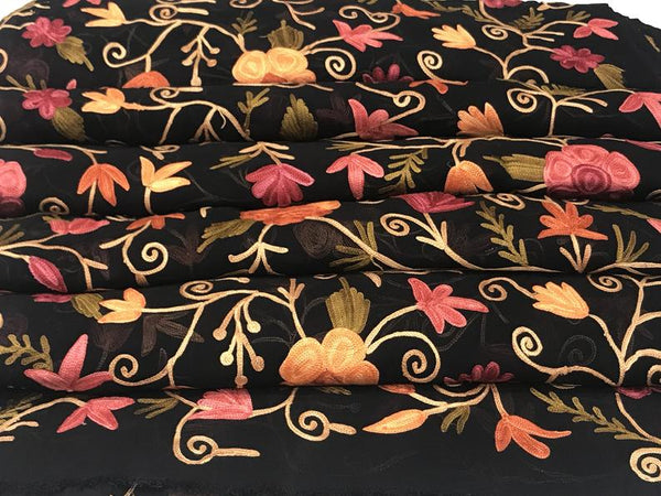 Floral patterned fabric with pink, orange, and yellow flowers on a black background