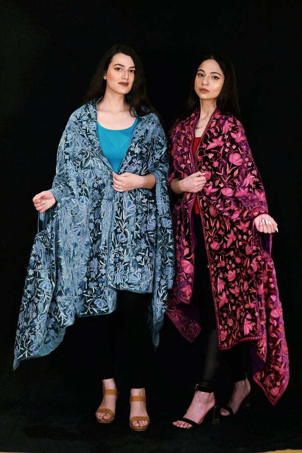 #JungleGreen Two women wearing patterned shawls against a black background