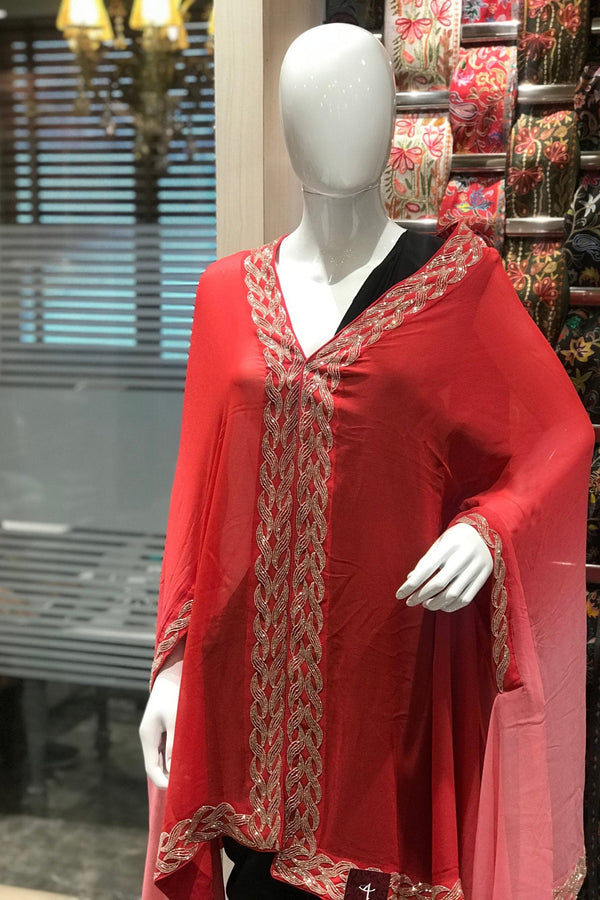 Red traditional outfit with intricate patterns on a mannequin in a store setting.