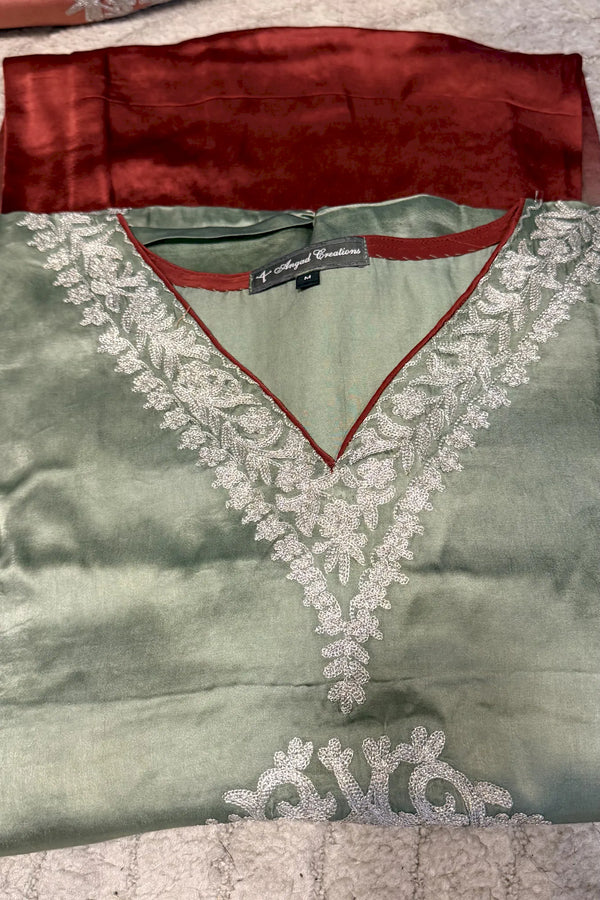 #OmbreRust&Green Green dress with red trim and lace detailing on a textured surface